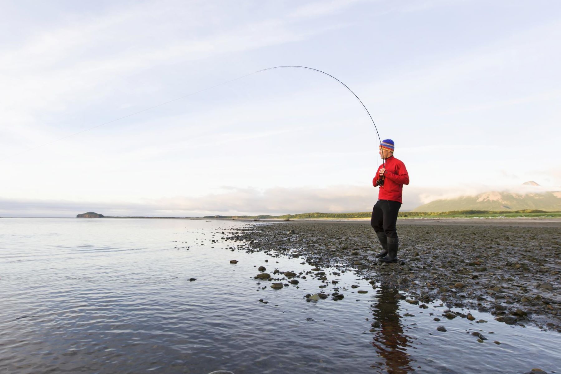 A man fishes on a river in the Alaska wilderness